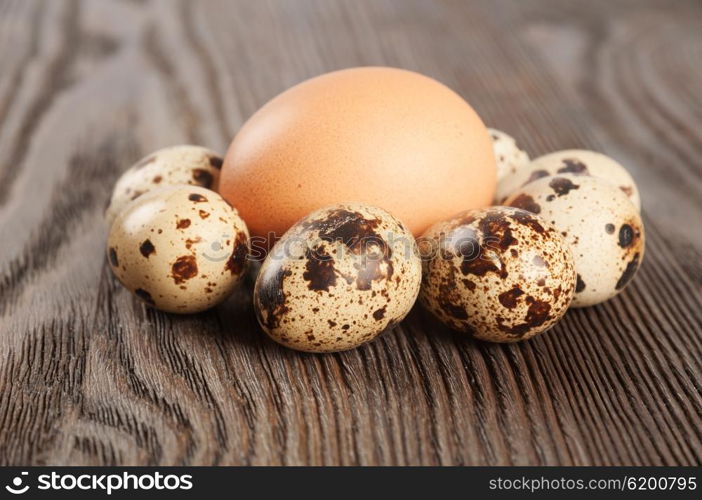 Quail and chicken eggs on a wooden table