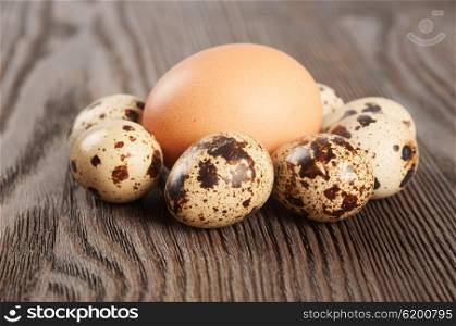 Quail and chicken eggs on a wooden table
