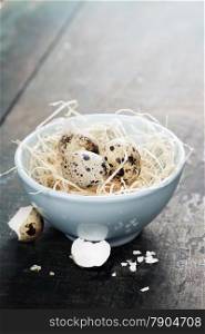 Quail easter eggs in a bowl on wooden table