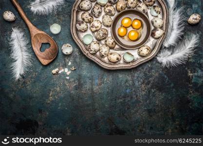 Quail eggs and cooking spoon on rustic background, top view, place for text
