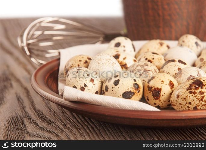 Quail eggs in a clay plate on a wooden table