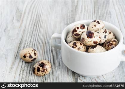 Quail eggs in a white plate on a wooden background