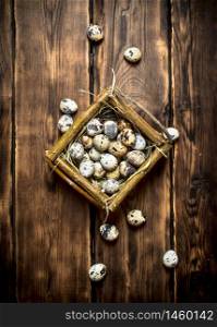 Quail eggs in the basket. On wooden background.. Quail eggs in the basket.