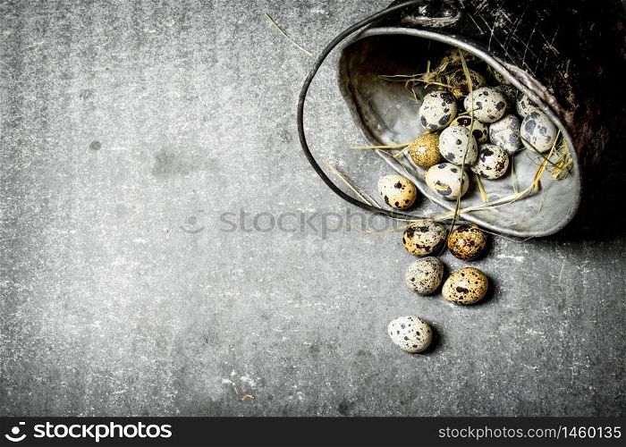 Quail eggs with hay in the old pot. On the stone table.. Quail eggs with hay in the old pot.
