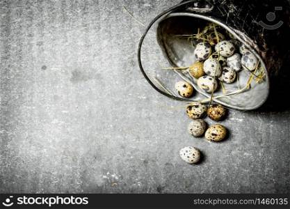 Quail eggs with hay in the old pot. On the stone table.. Quail eggs with hay in the old pot.