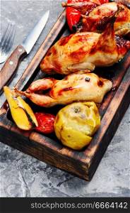 Quail fried with orange and apples.Roasted quail. Whole grill quails