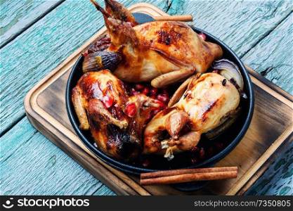 Quail roasted with pomegranate sauce in frying pan. Quail fried in a frying pan