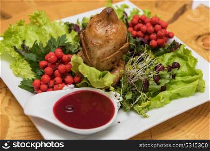 quail roasted with sweet and sour cranberry sauce. quail roasted with sweet and sour cranberry sauce decorated with rowanberry