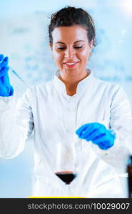 Quality control expert inspecting red wine in the laboratory