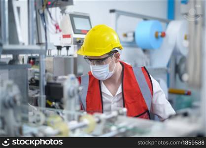 Quality control (QC) engineer monitoring and checking machine system in manufacturing factory