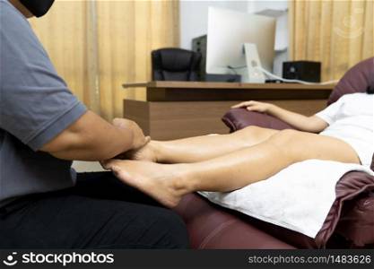 Quarantine asian woman do foot massage at home while city lockdown for social distance due to coronavirus pandemic. Massage and spa is one of service business that shutdown while city lockdown.