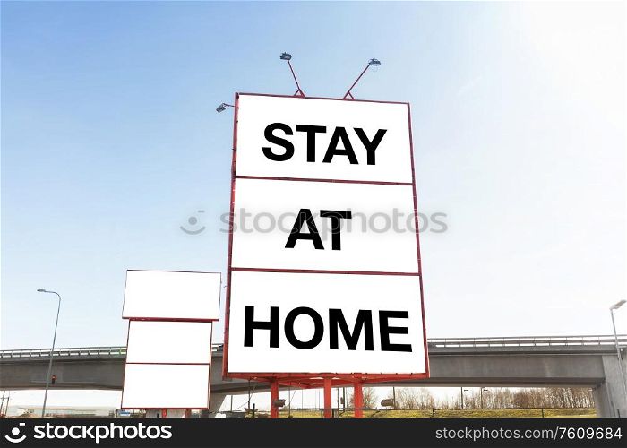 quarantine, caution and information concept - big white billboard with stay at home words in city. big billboard with stay at home words in city