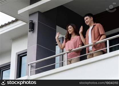 quarantine couple greeting neighbors from balcony of the home, coronavirus pandemic