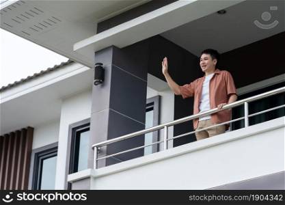 quarantine man greeting his neighbors from balcony of home, coronavirus pandemic