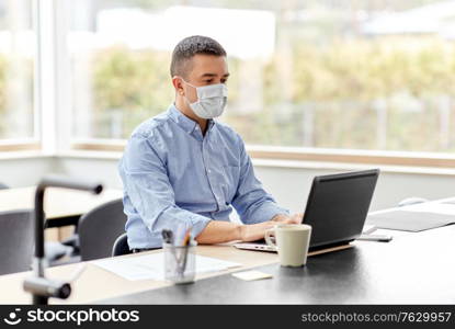 quarantine, remote job and pandemic concept - middle-aged man wearing face protective medical mask for protection from virus disease with laptop computer working at home office. man in mask with laptop working at home office