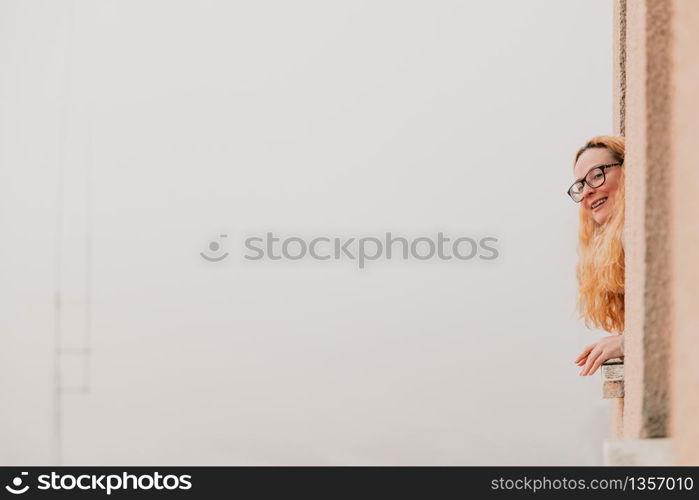 Quarantined woman bending over the window watching outside