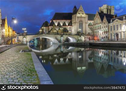 Quay Graslei, picturesque medieval St Michael&amp;#39;s Bridge and church at night in Ghent, Belgium