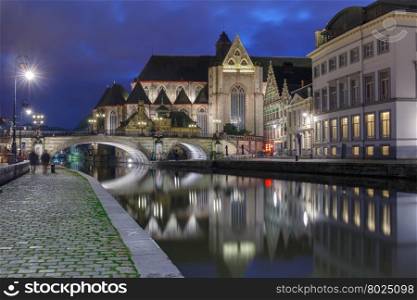 Quay Graslei, picturesque medieval St Michael&amp;#39;s Bridge and church at night in Ghent, Belgium
