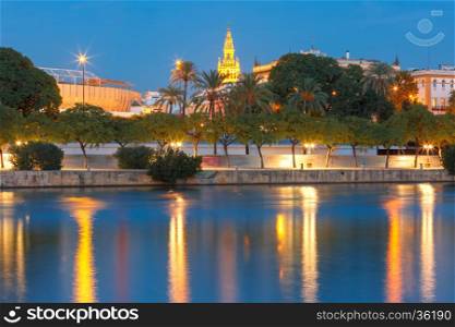 Quay of the river Guadalquivir, Famous Bell Tower named Giralda and Maestranza during evening blue hour, Seville, Andalusia, Spain