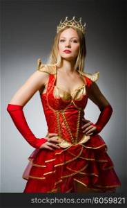 Queen in red costume against dark background