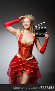Queen in red dress with movie clapboard