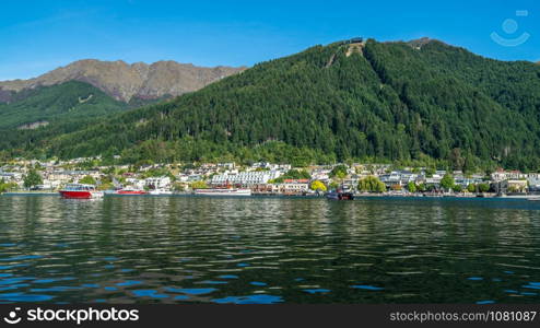 Queenstown lakefront city center shot at Lake Wakapitu, the famous lake of Queenstown, center of tourism, water sport and boat tours, South Island of New Zealand.