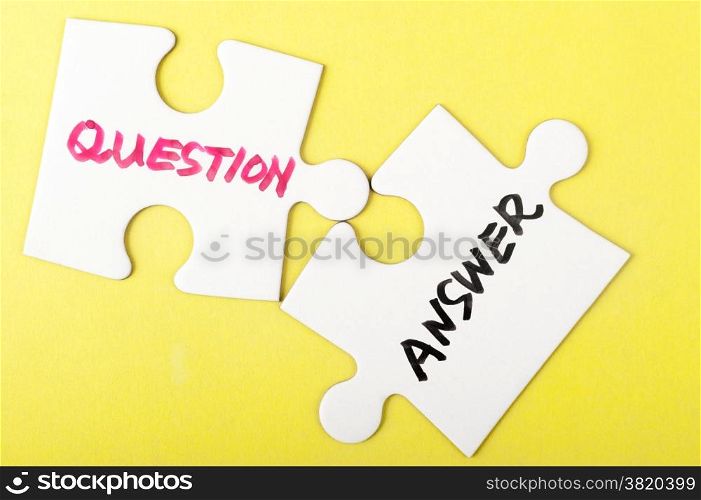 Question and answer words written on two pieces of jigsaw puzzle