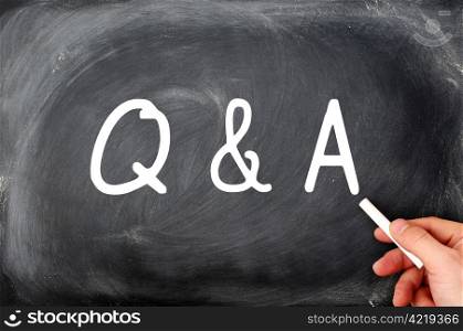 Question and Answer written on a blackboard with a hand holding chalk
