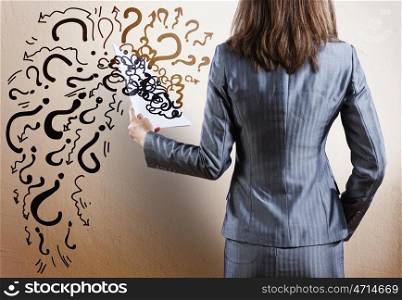 Question concept. Rear view of businesswoman with papers in hand