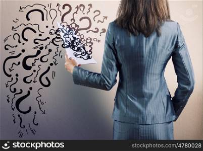 Question concept. Rear view of businesswoman with papers in hand