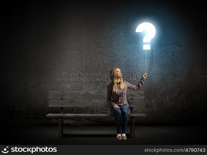 Question concept. Young woman in casual holding balloon shaped like question mark