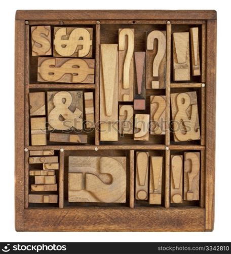 question mark, exclamation point, ampersand, and other punctuation symbols - vintage letterpress printing blocks in small wooden typesetter box with dividers, isolated on white