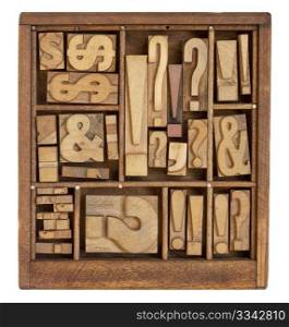 question mark, exclamation point, ampersand, and other punctuation symbols - vintage letterpress printing blocks in small wooden typesetter box with dividers, isolated on white
