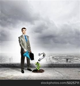 Question mark. Image of businessman watering green question mark