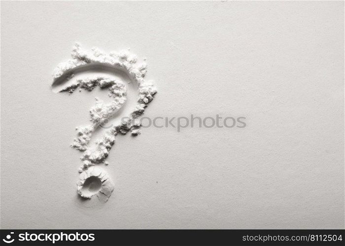 Question mark on powder background in black and white.