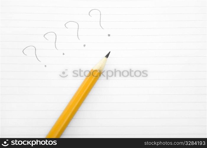 question mark written on paper by a yellow pencil