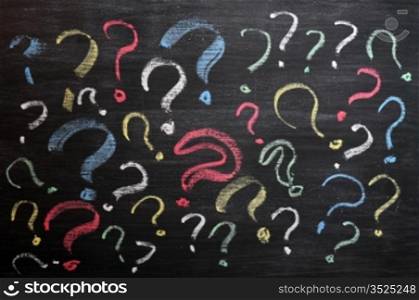 Question marks on chalkboard. Decision, confusion, FAQ or other concept. Hand writing with chalk on school black board.