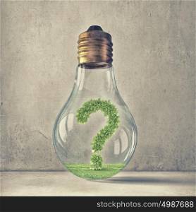 Question of ecology and energy saving. Green question mark inside glass light bulb