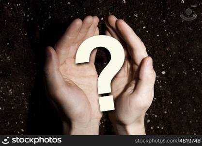 Question of ecology problem. Question mark icon in male palms on soil background