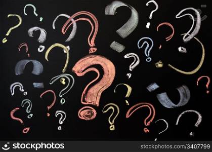 Questions, decision making or uncertainty concept - a pile of colorful question marks drawn on a blackboard