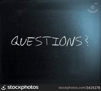 ""Questions?" handwritten with white chalk on a blackboard."