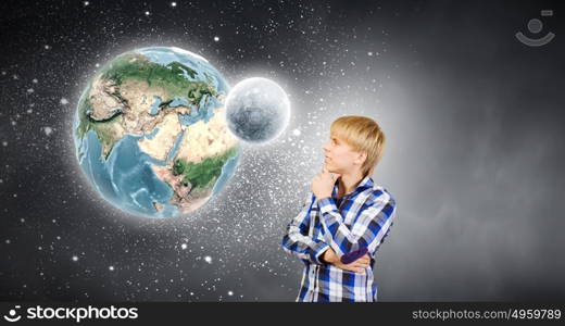 Questions of universe. Young handsome man in casual thinking over something. Elements of this image are furnished by NASA