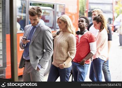 Queue Of People Waiting At Bus Stop