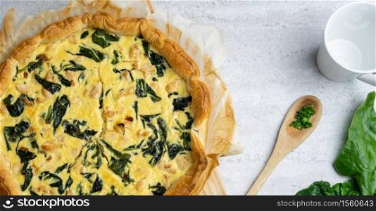 Quiche filled with chicken, chard with wooden spoon on soft background.