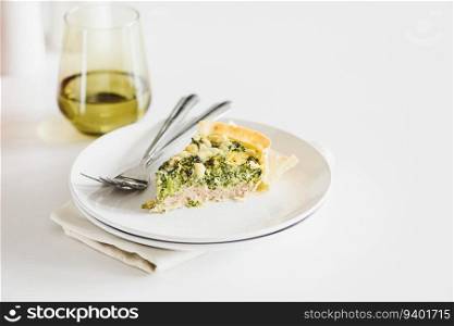 Quiche. Healthy homemade chicken pie with broccoli and spinach on white wooden table