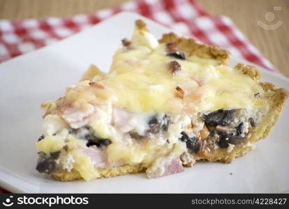 quiche with ham cheese salami muchrooms beans eggs in a white plate