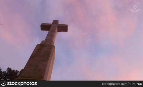 Quick clouds on the sunset sky over the big cross, time lapse