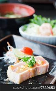 Quick grilled Sashimi with spicy sauce served with fresh vegetable on plate, japanese style cuisine
