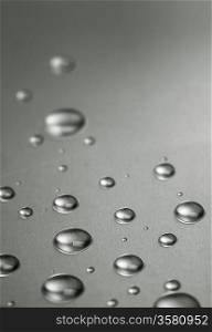 Quicksilver. Abstract still-life with liquid droplets over steel surface