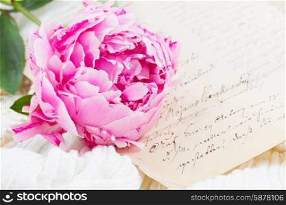 quill pen and antique letters. Pink peony with antique letter on white lace background